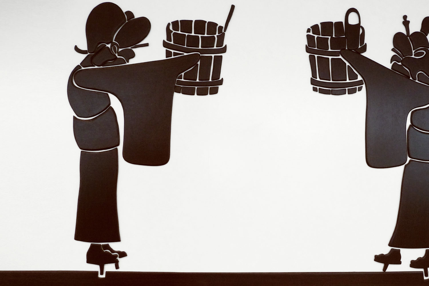 Aus Holz ausgeschnittene Geisha-Figuren, die Wasserzuber tragen.