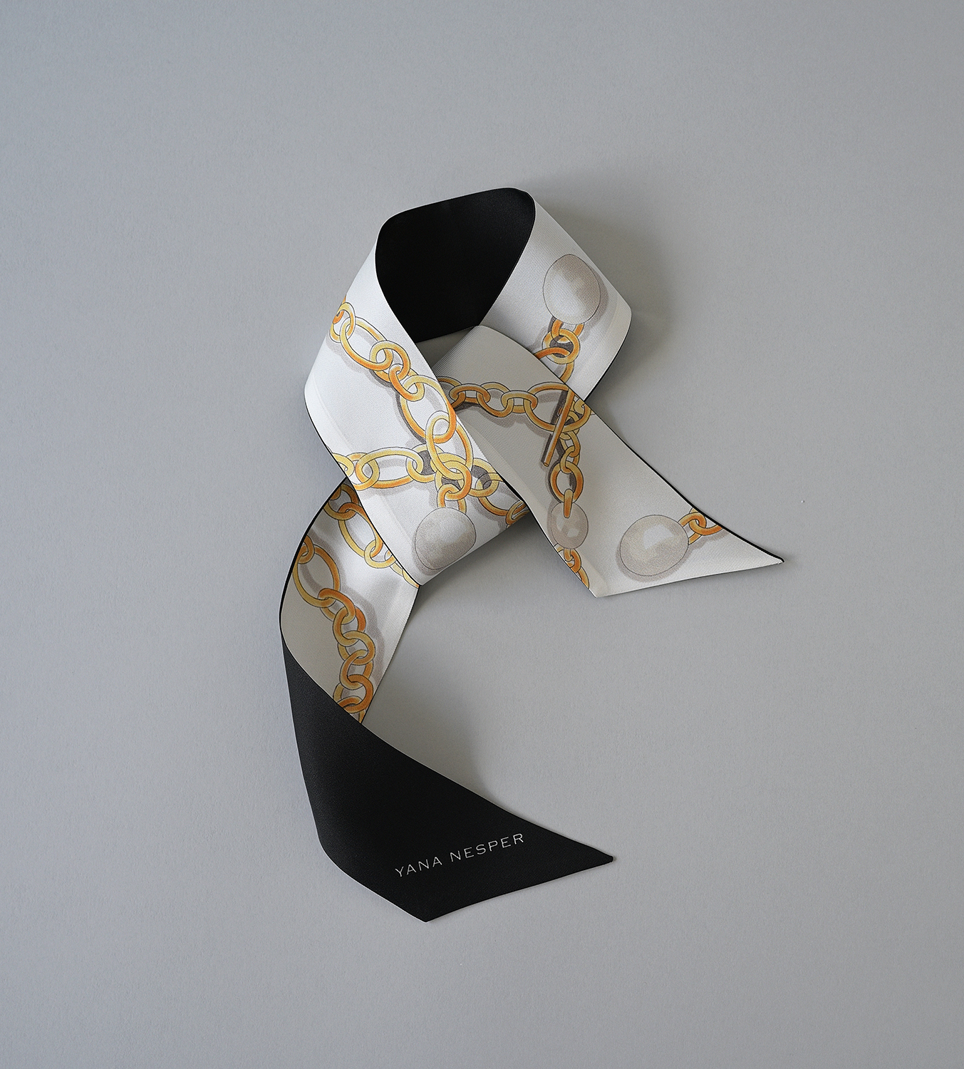 Schmales doppellagiges Seidenband mit einem Muster aus einer gezeichneten Gliederkette mit Perlen.